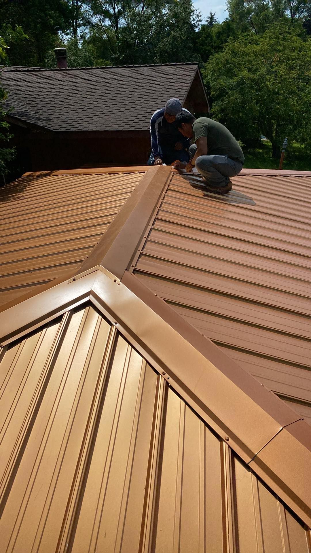 Two men are working on the roof of a house.