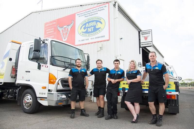 Five Staff in Black Uniforms Stand Beside a White Delivery Truck — Auto Inspections & Road Services N.T in Woolner, NT