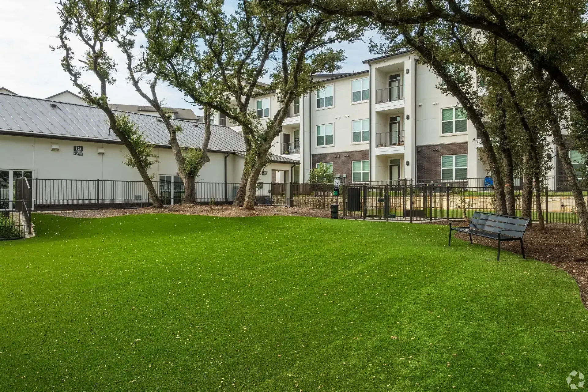 Spacious business center with a couch, chairs, tables, and a desk at The Gabriel, which offers Cedar Park, TX apartments for rent near The Domain.