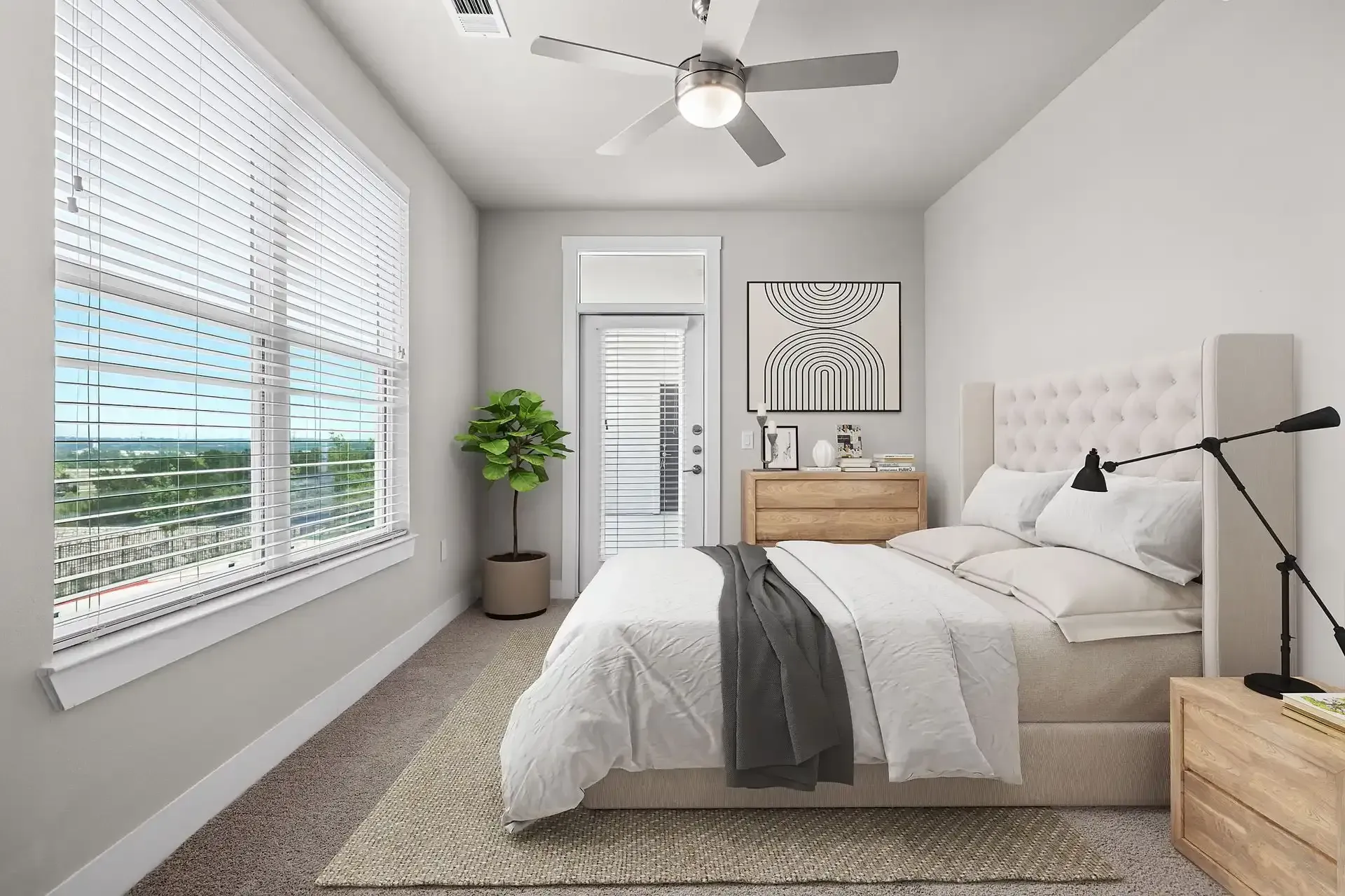 Apartment bedroom with a bed, dresser, nightstand, and ceiling fan at The Gabriel, which offers apartments for rent near Cedar Park.