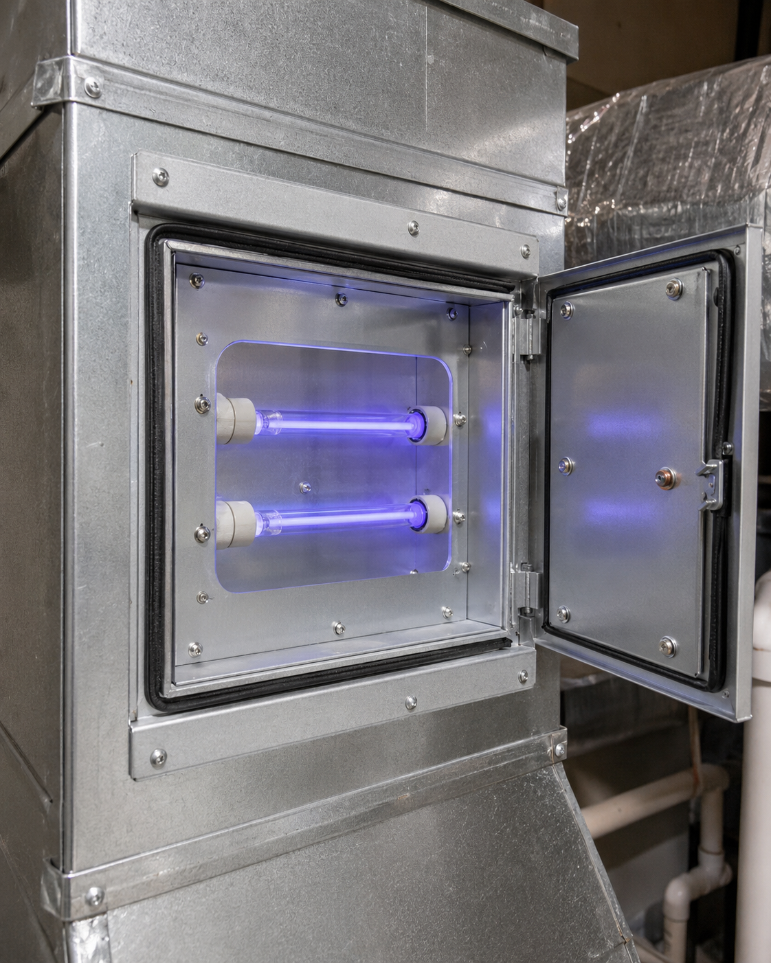 Open metal chamber with two glowing purple UV tubes inside and a hinged door open