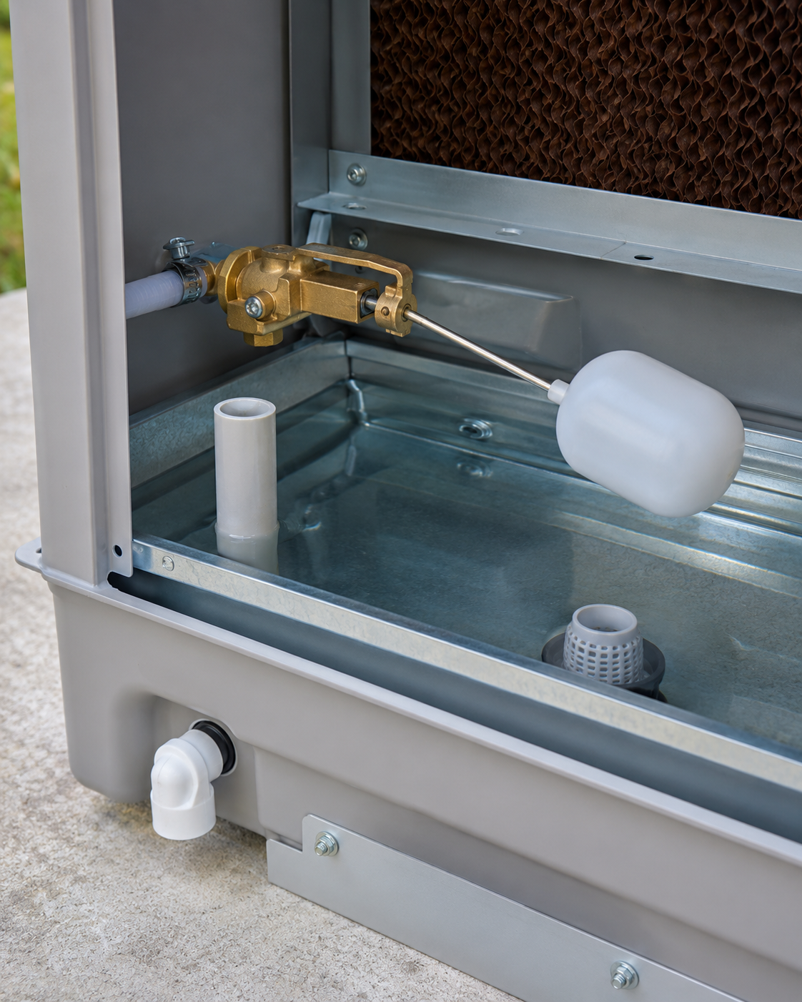 Open appliance panel showing plumbing components and a white float inside a metal basin