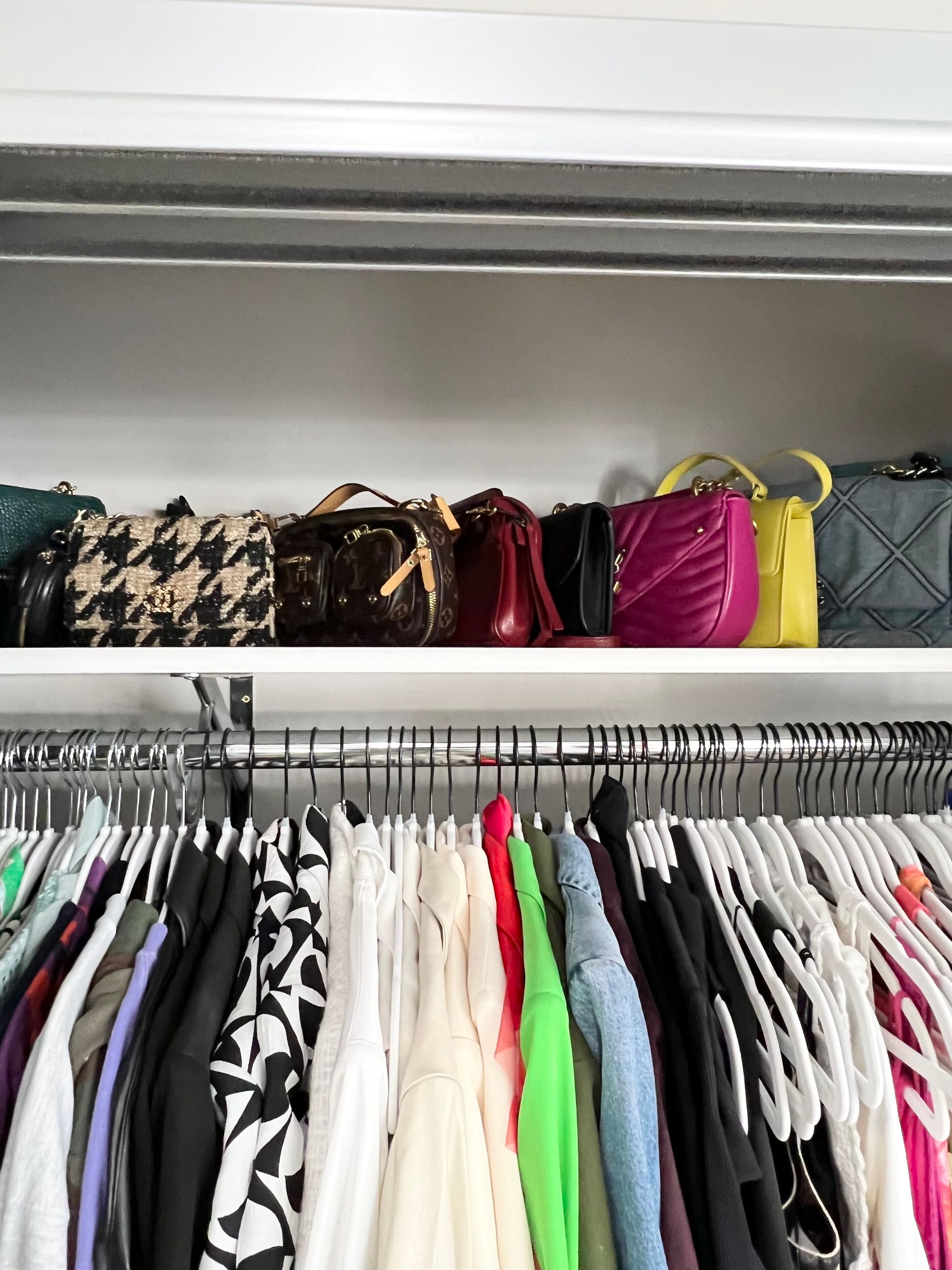 A closet filled with lots of clothes and handbags.