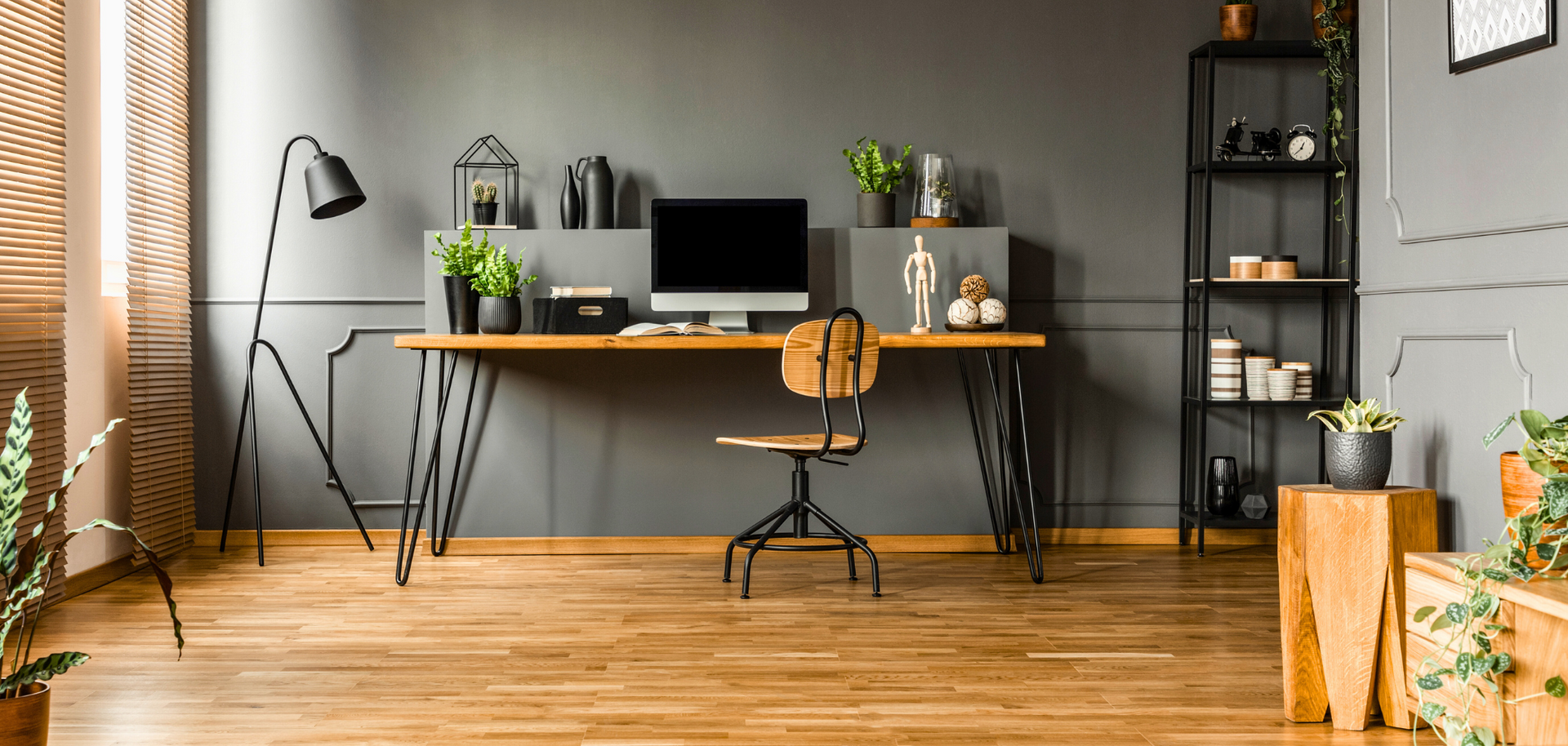 There is a desk with a computer on it in the middle of the room.