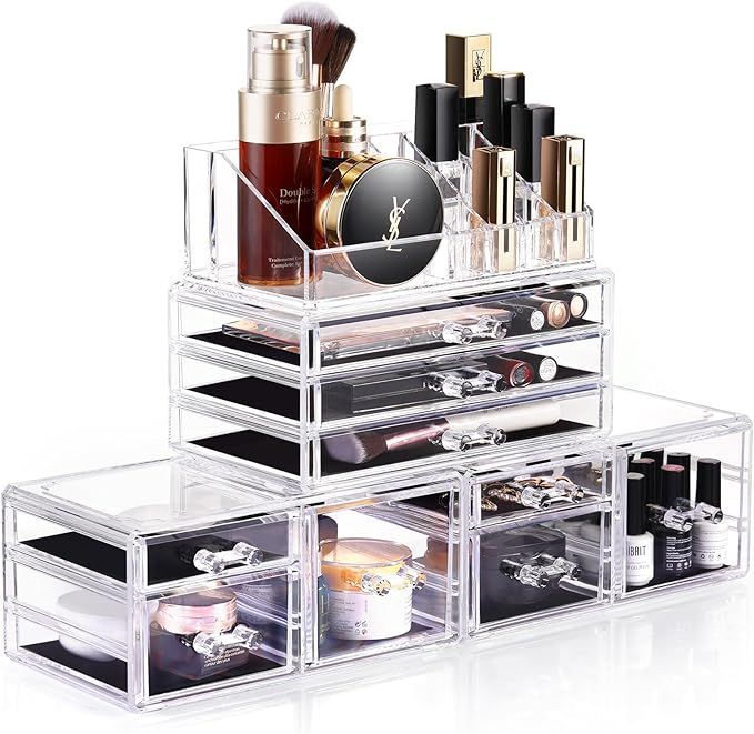 A clear acrylic makeup organizer with drawers filled with cosmetics.