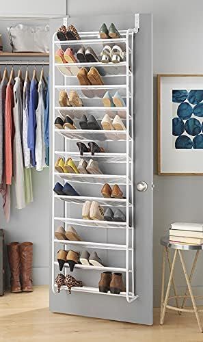 A shoe rack is hanging over a door in a closet.