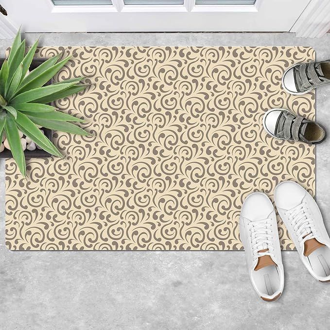 A door mat with a floral pattern and a pair of shoes on it.