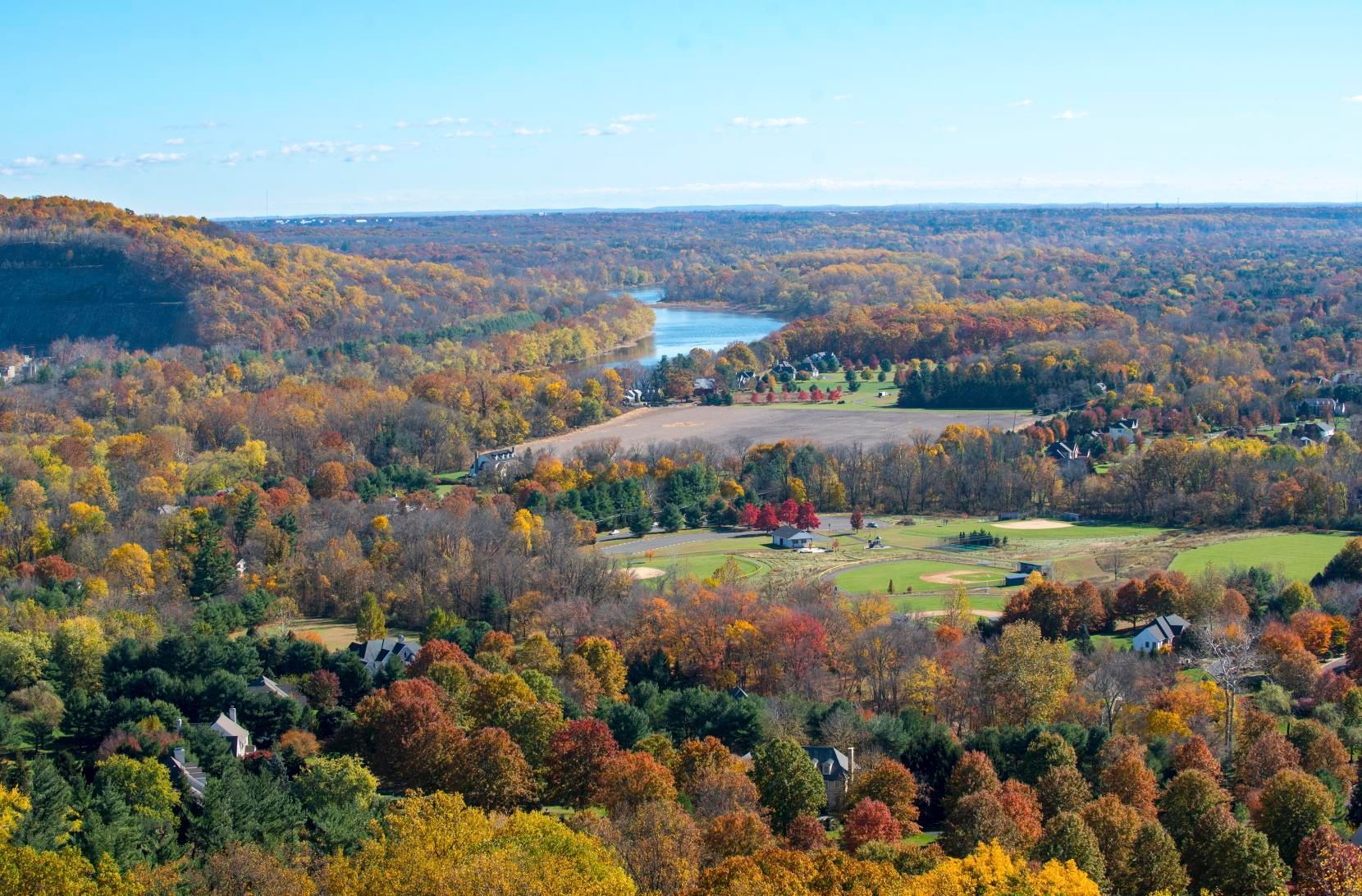 Autumn landscape with colorful trees, rolling hills, and a river in the distance in Bucks County, PA
