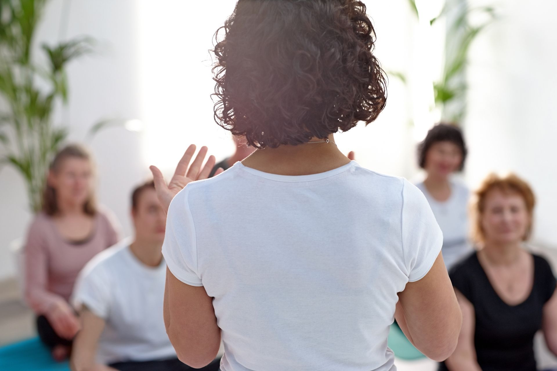 A woman is standing in front of a group of people.