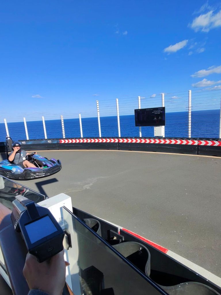 Go-kart track with blue sky and ocean view, seen from a kart driver’s perspective