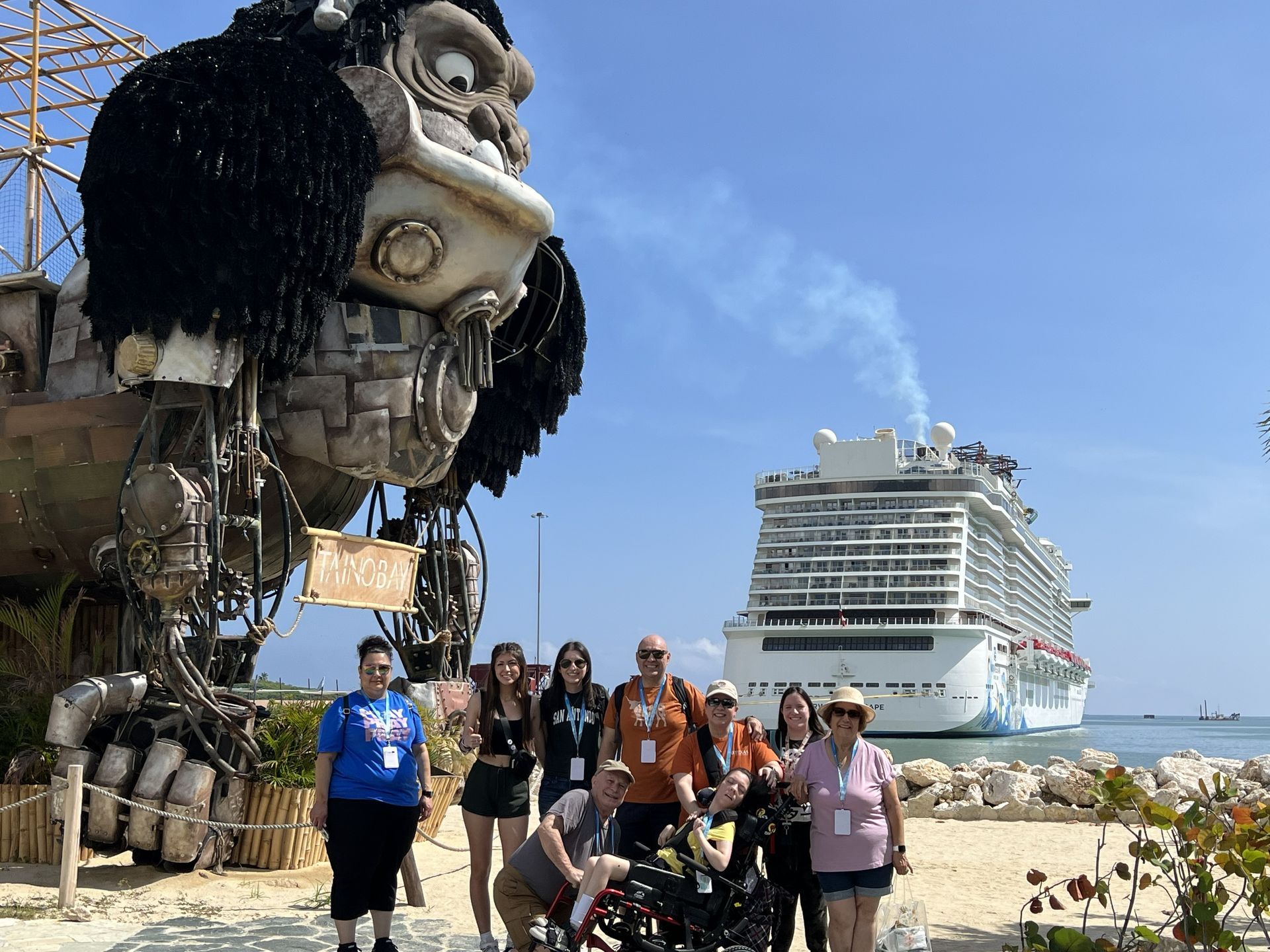 Group posing beside a giant gorilla sculpture with a cruise ship in the background on a sunny waterfront