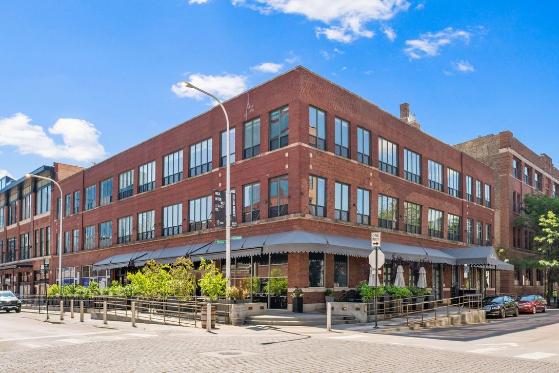 945 W Fulton Market Apartments building with a lot of windows is on the corner of a street.