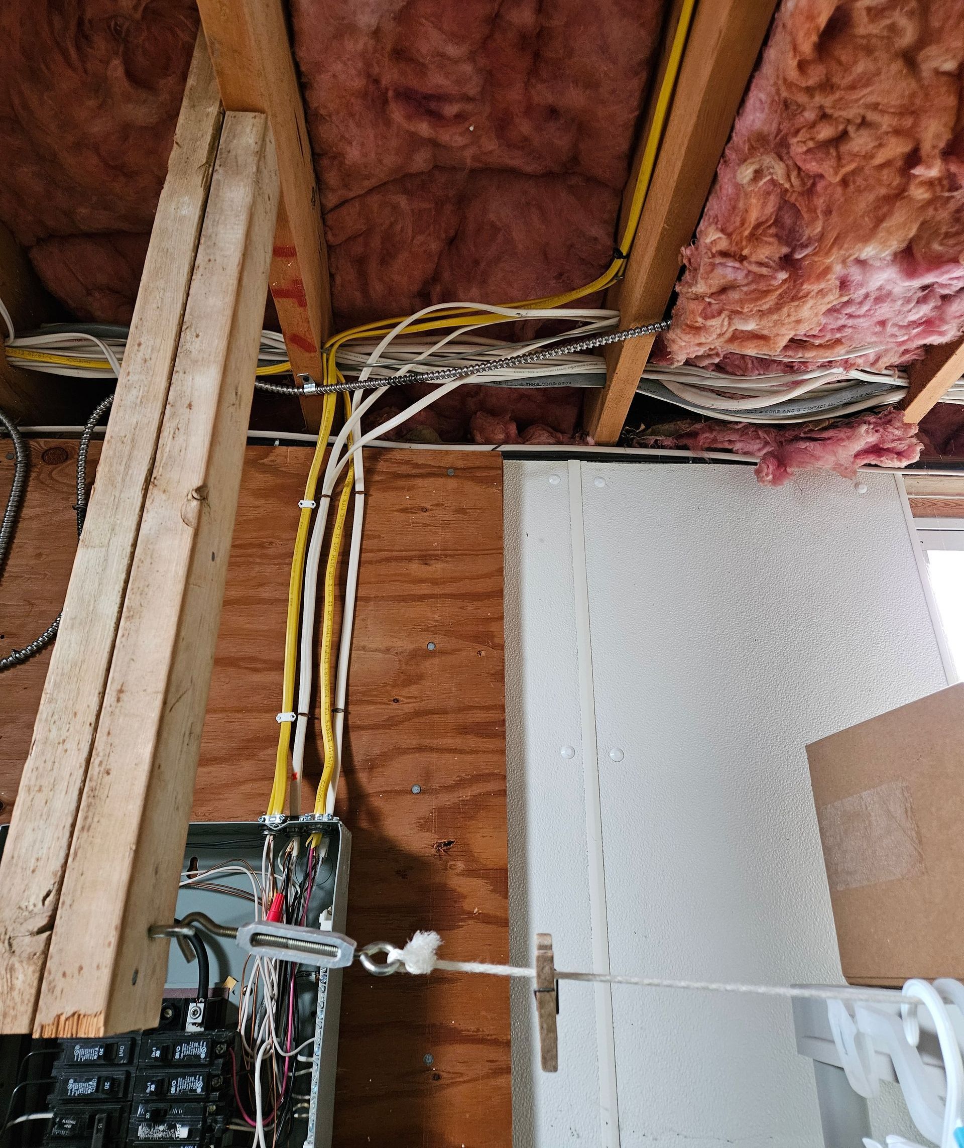 A bunch of wires are hanging from the ceiling of a house.