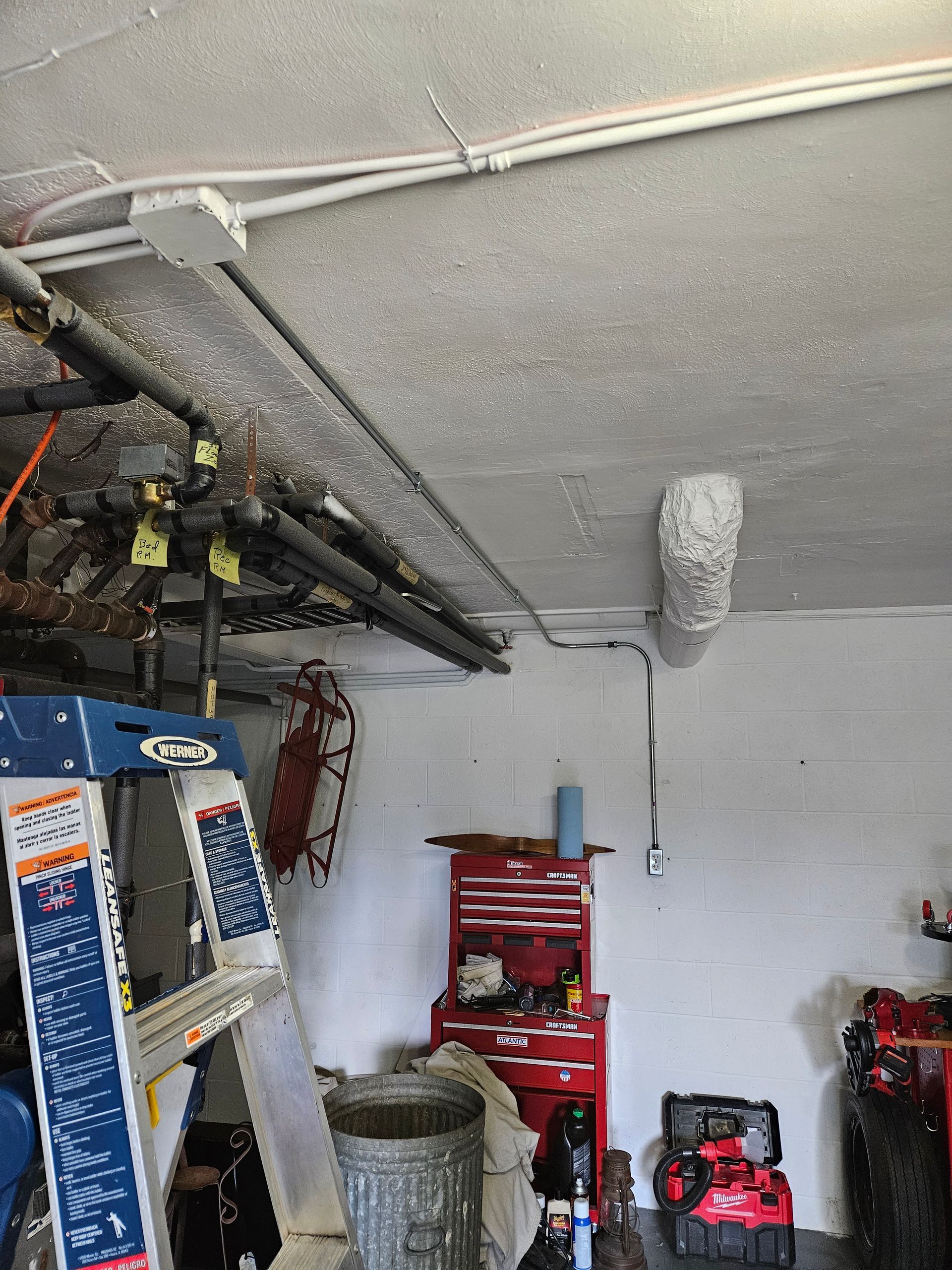 A garage filled with lots of tools and a ladder.