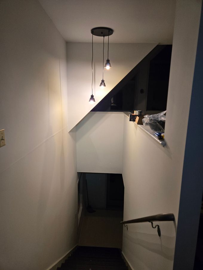 A staircase with lights hanging from the ceiling