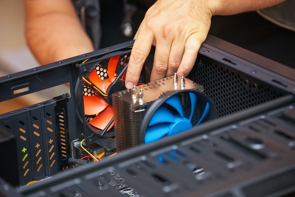 A person is installing a fan into a computer case.