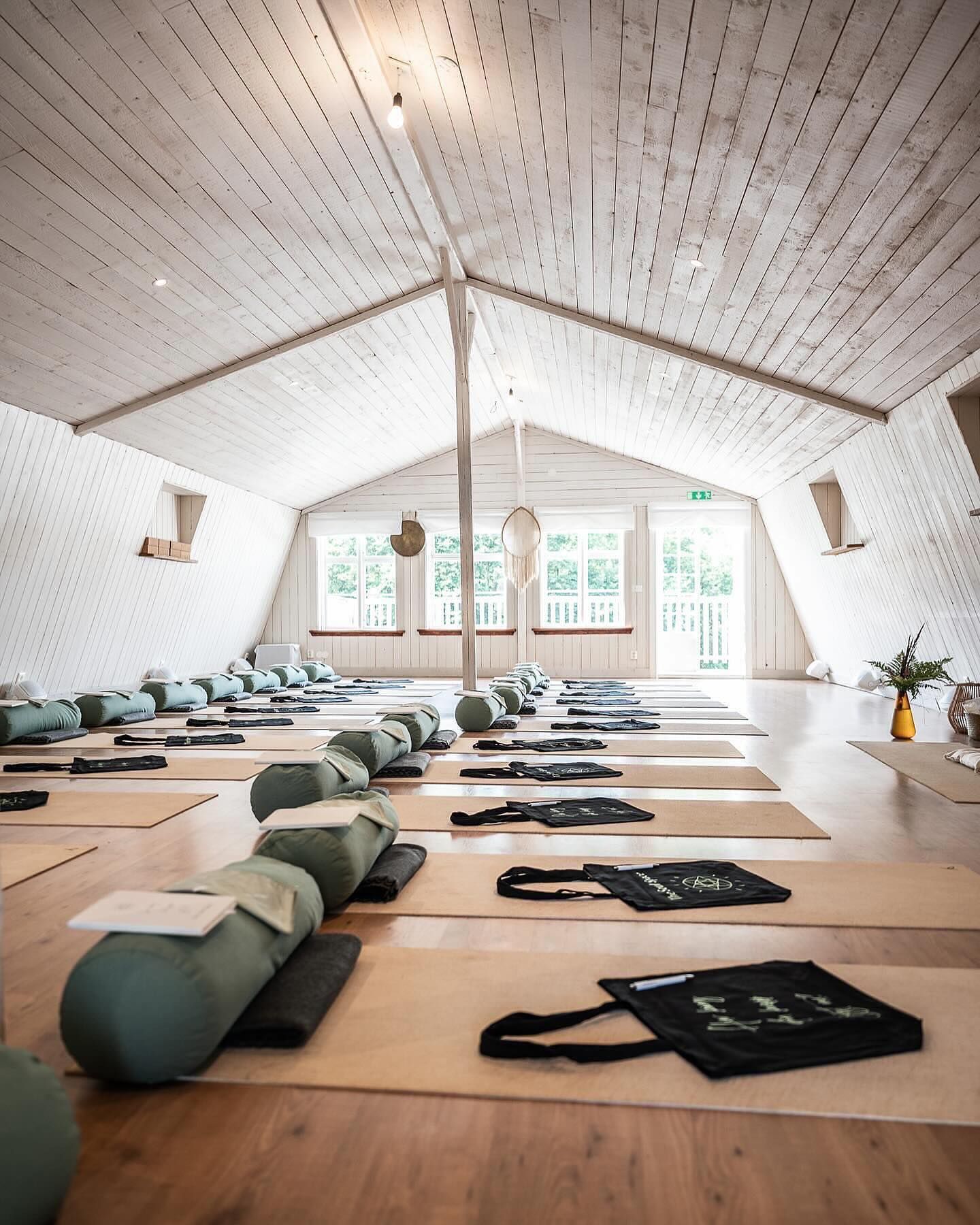 A large room filled with yoga mats and pillows