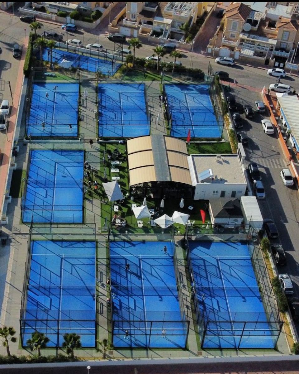An aerial view of a tennis court in a city