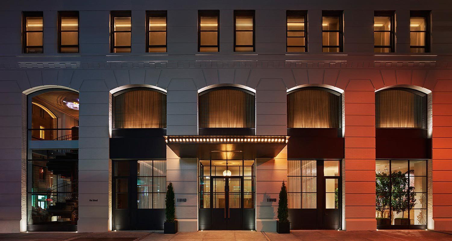 Lit brick building at night with arched windows and warm interior lights