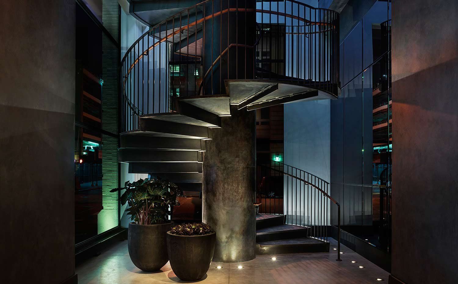 a spiral staircase with plants and lights