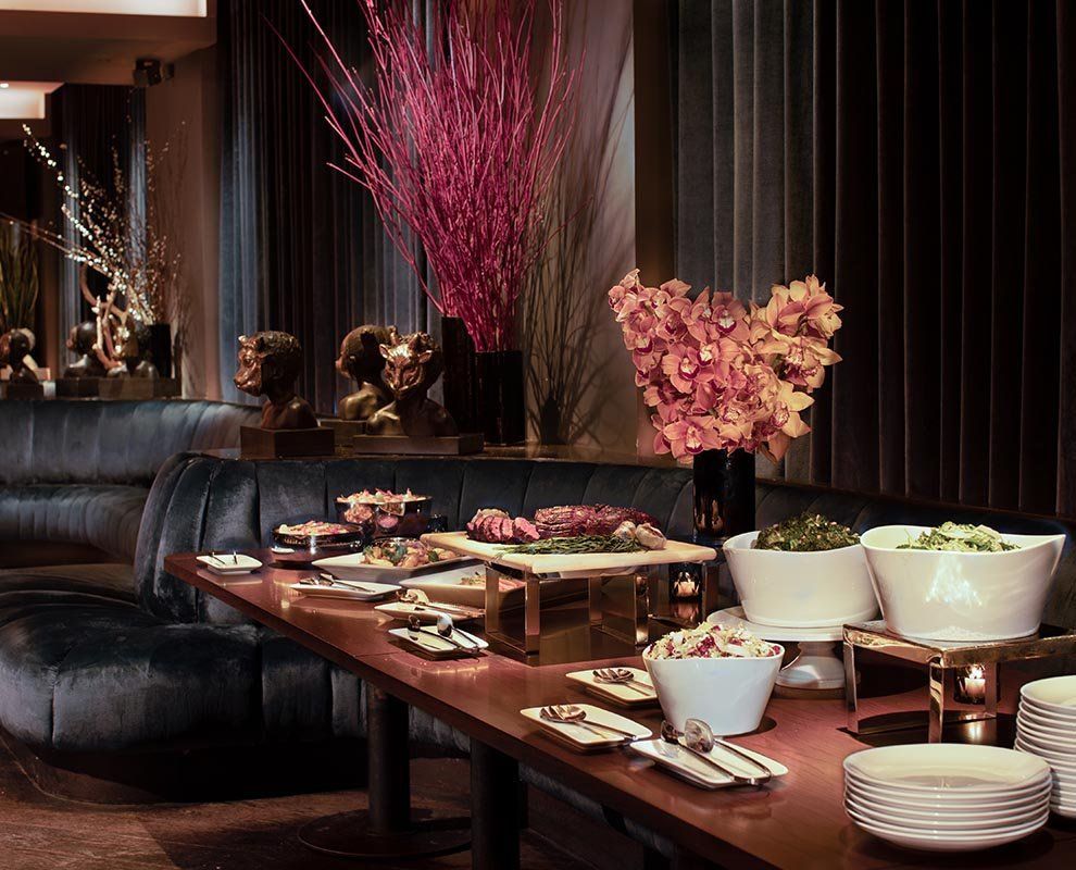 A buffet table with various dishes and flowers