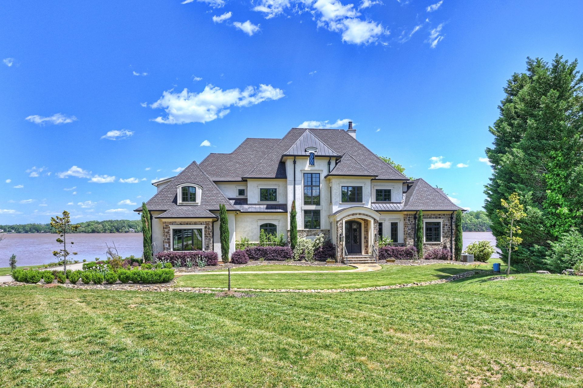 a large house sits next to a body of water | Charlotte, NC | Harland Building Group 