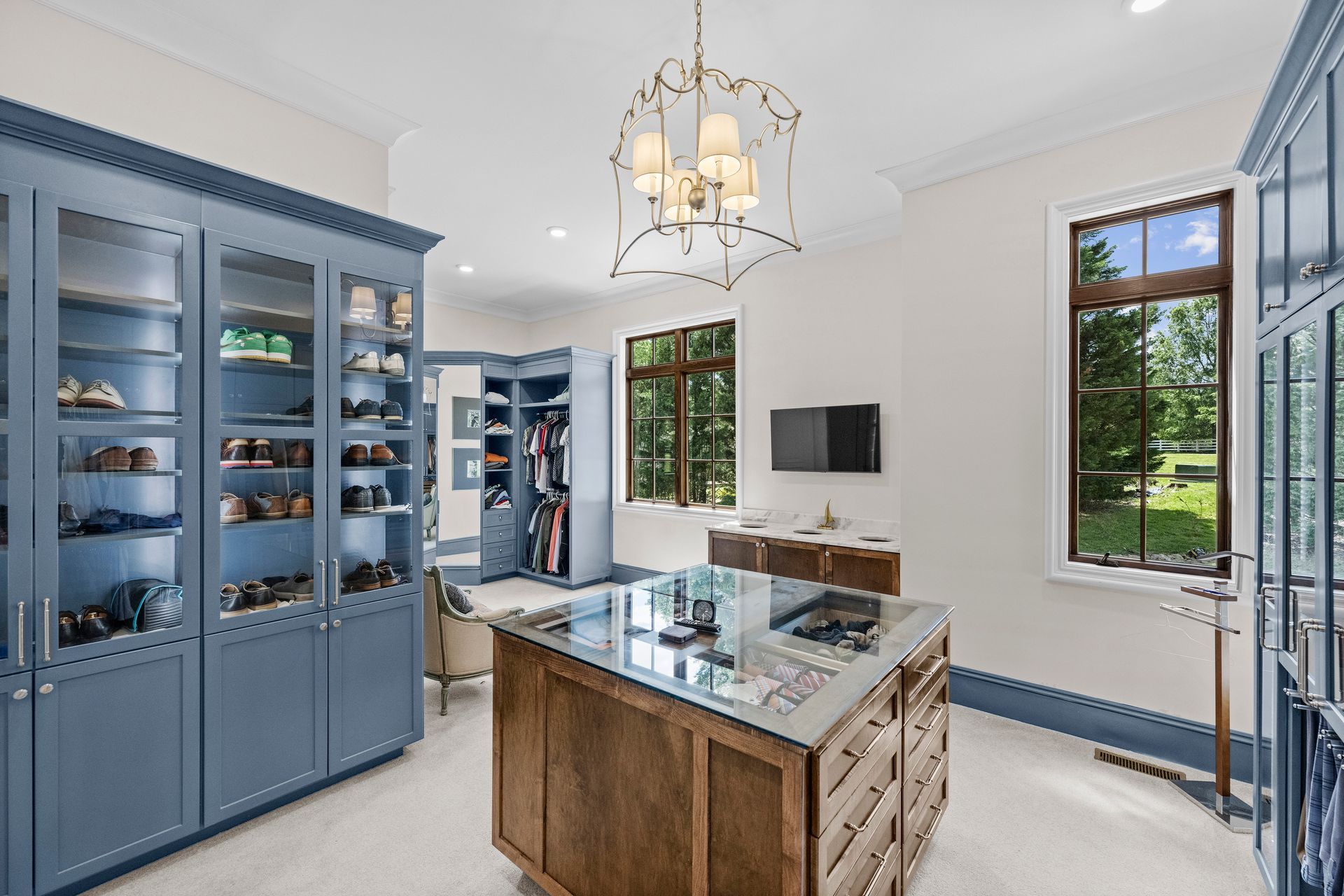 a walk in closet with blue cabinets and a glass island | Charlotte, NC | Harland Building Group 
