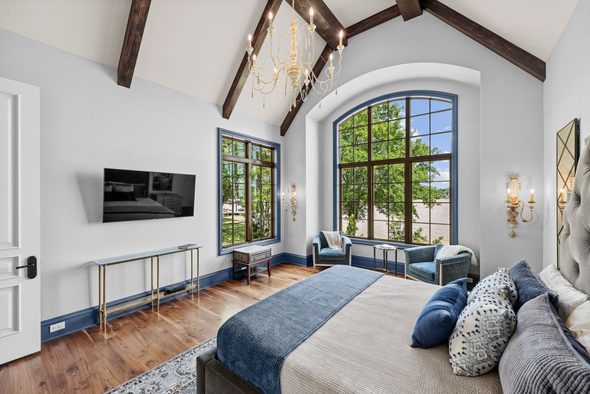 a bedroom with a large bed and a television on the wall | Charlotte, NC | Harland Building Group 