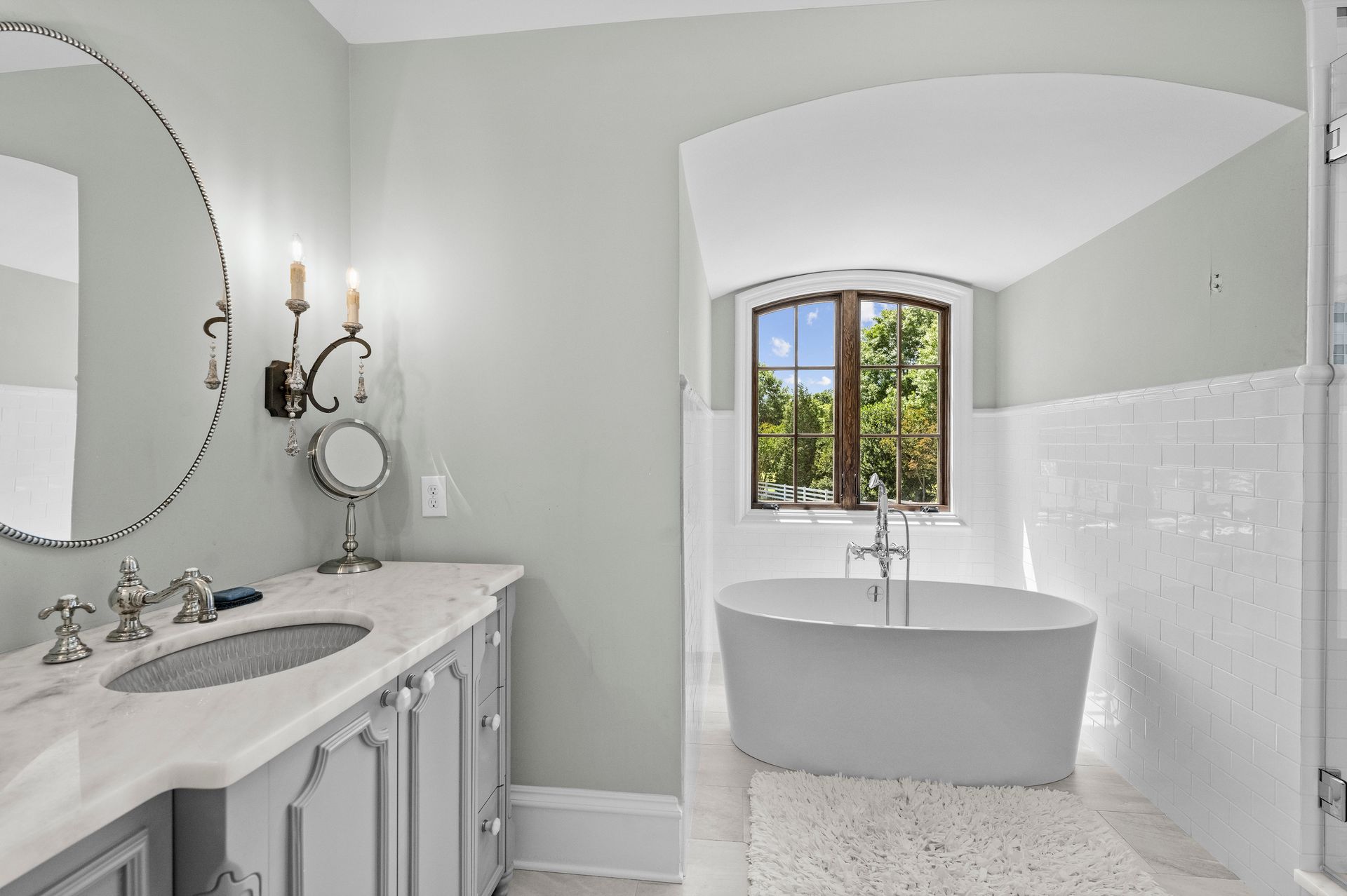 a bathroom with a white tub and a window | Charlotte, NC | Harland Building Group 