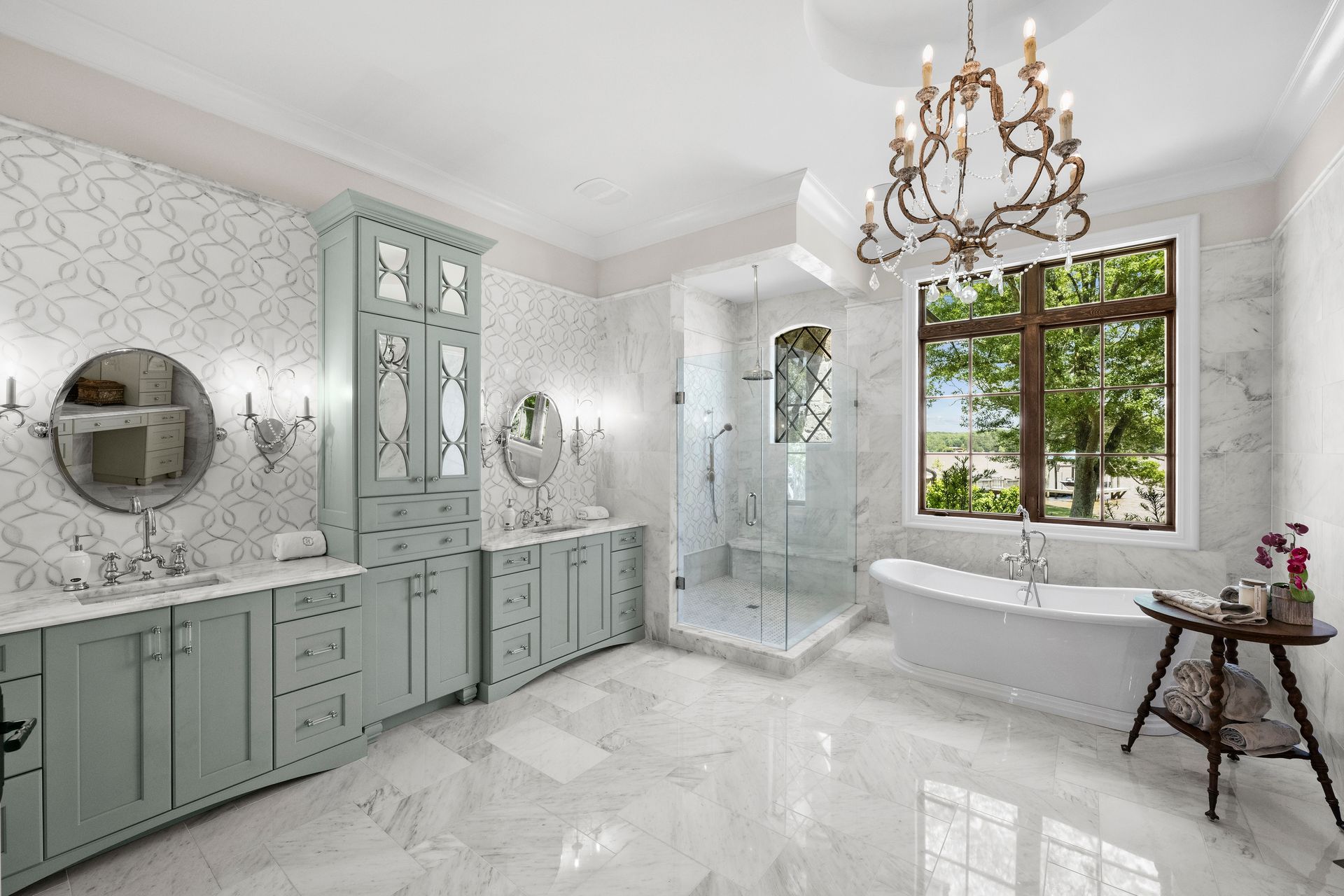 a bathroom with two sinks a tub and a chandelier | Charlotte, NC | Harland Building Group 
