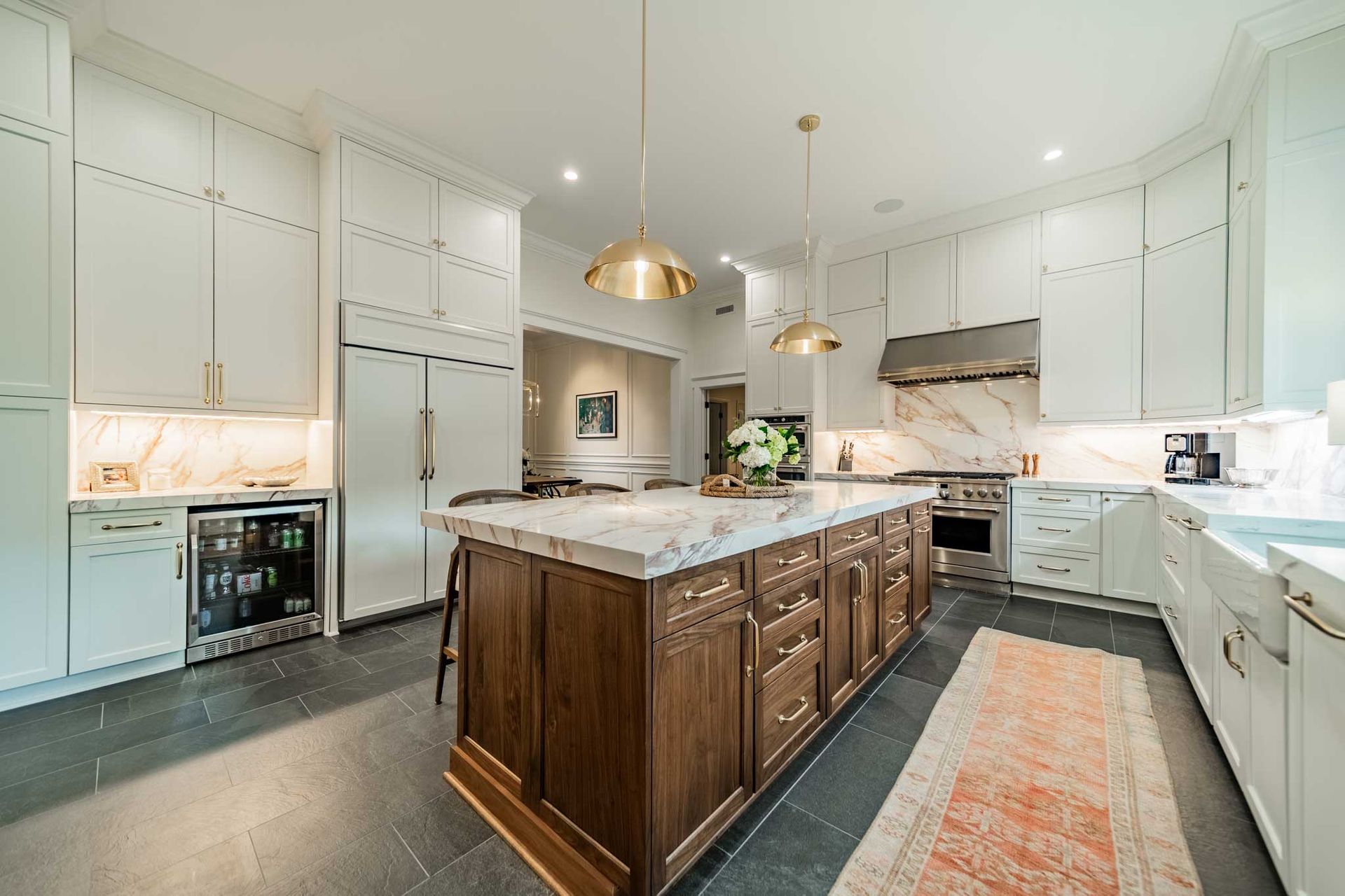 A kitchen with white cabinets and a large island in the middle.