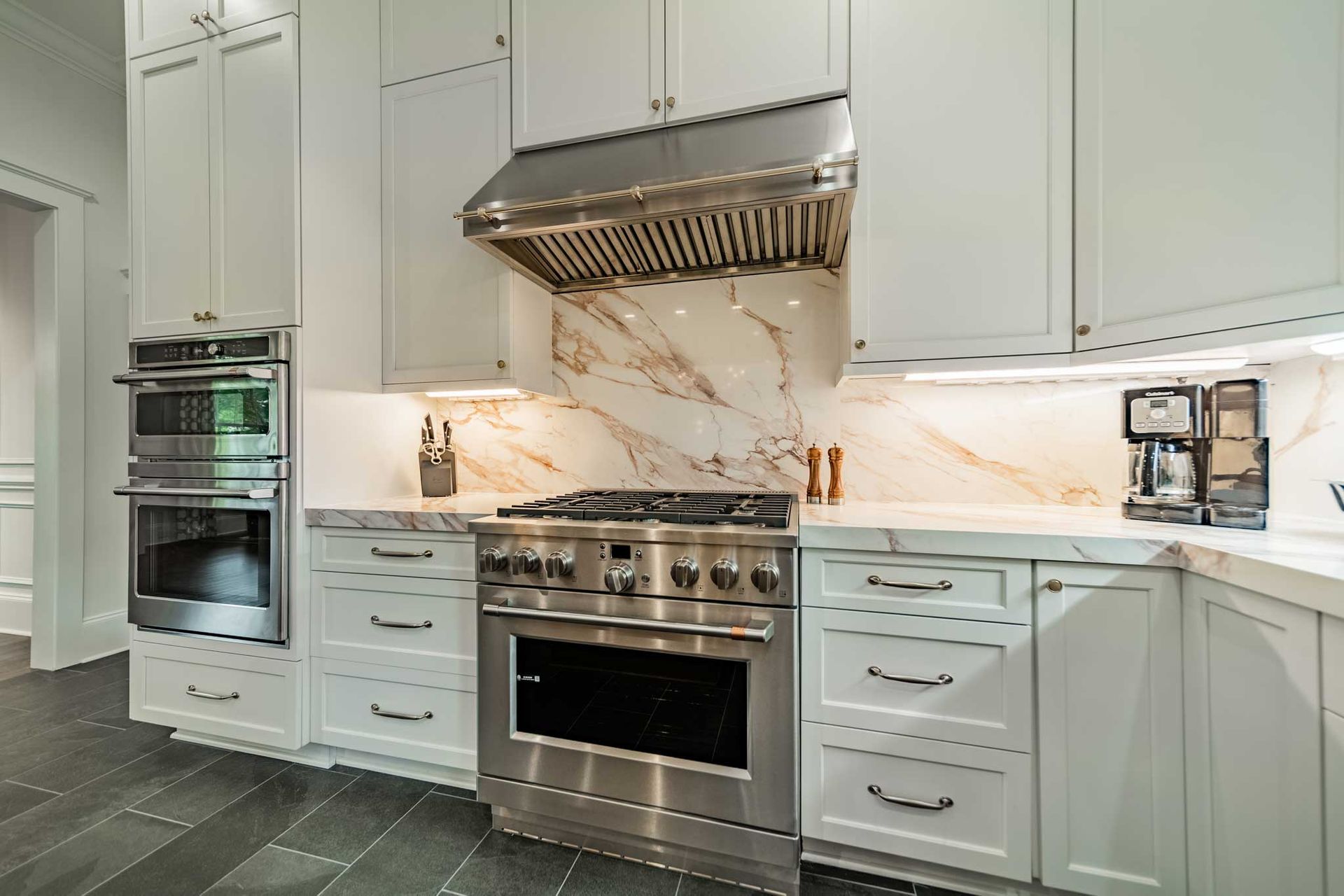 A kitchen with stainless steel appliances and white cabinets.