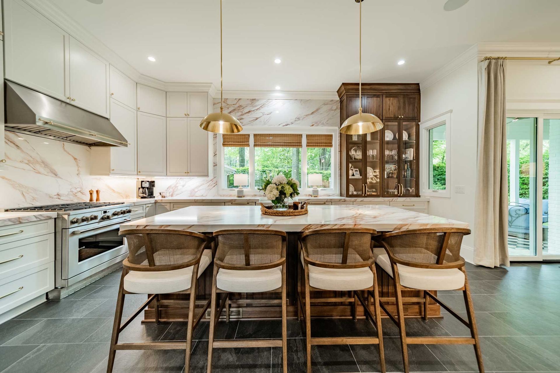A kitchen with a large island , stools and a stove.