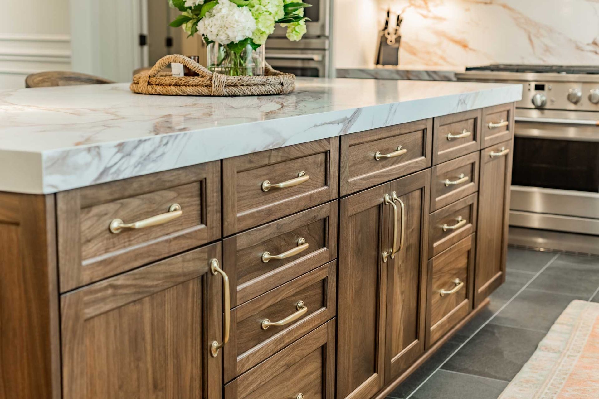 A kitchen with wooden cabinets and a marble counter top.