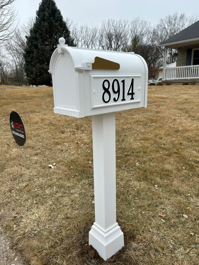 White mailbox on post with house number 8914 in a yard with winter grass.