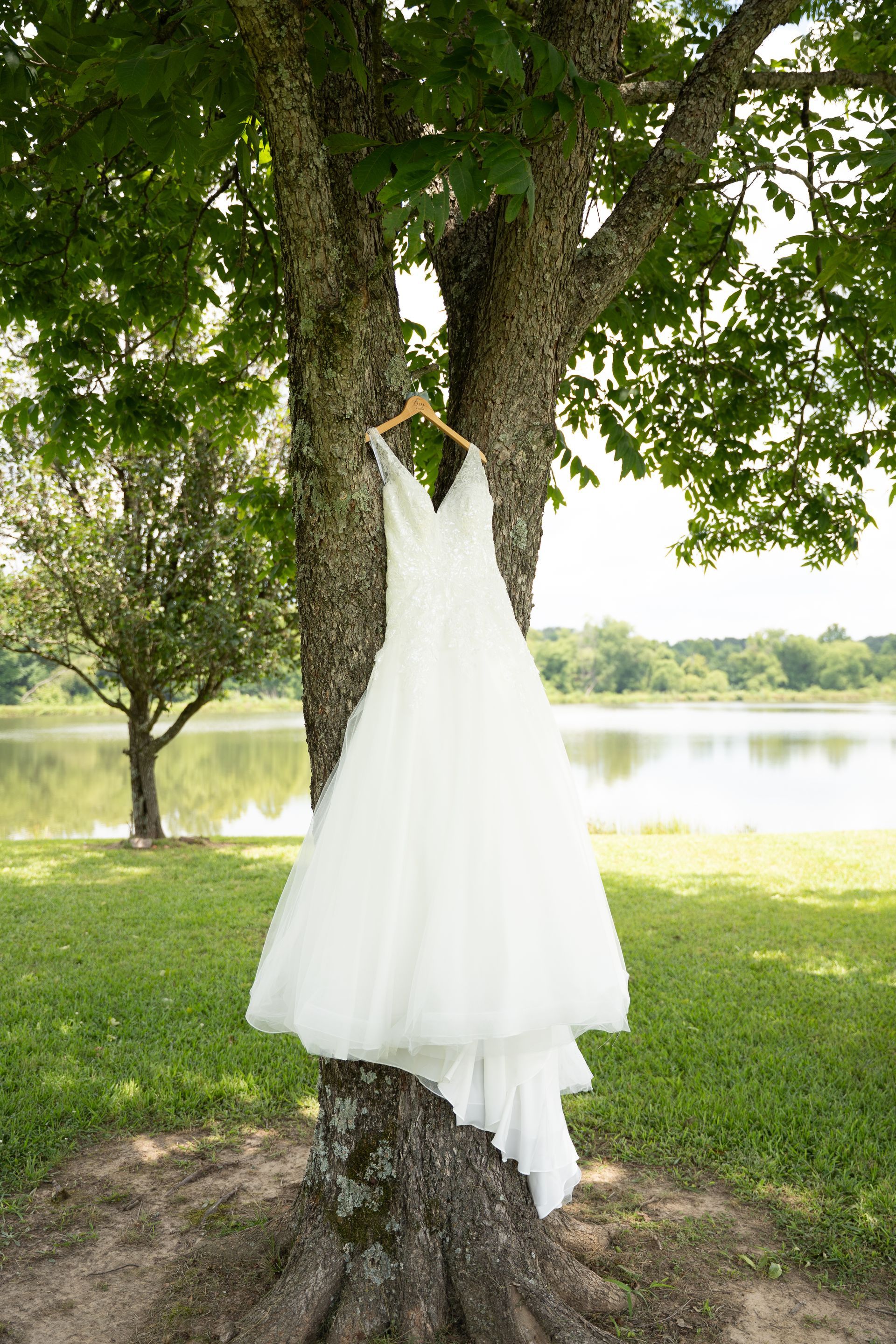 A bride and group posing in front of the lake