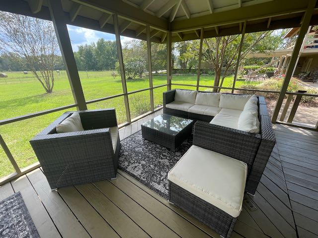 A screened in porch with a couch and chairs