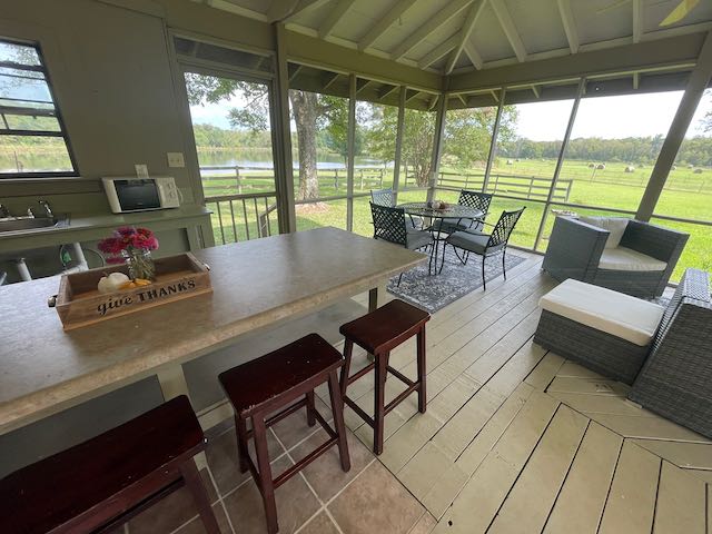 A screened in porch with a table and stools