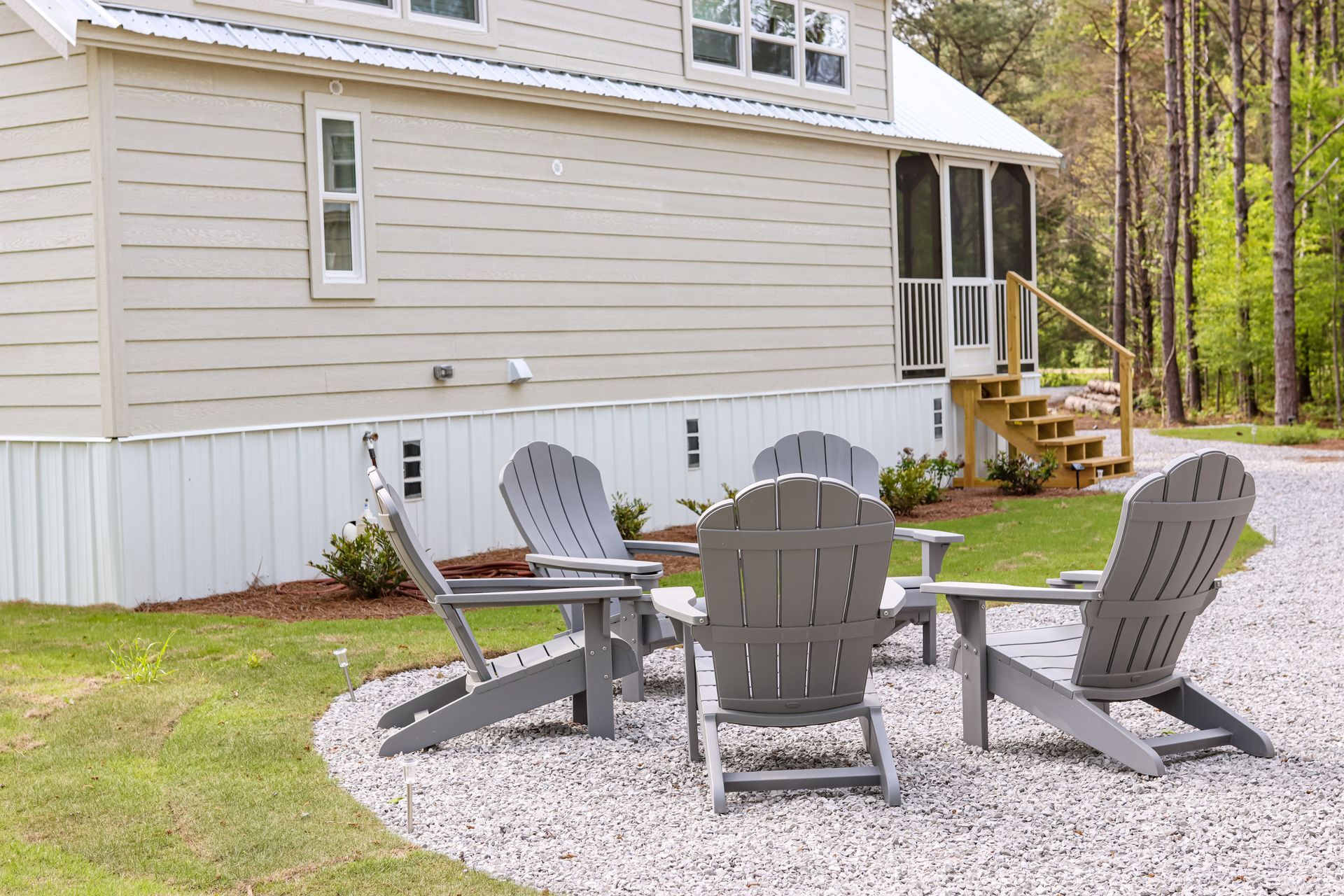 A group of chairs are sitting in front of a house.