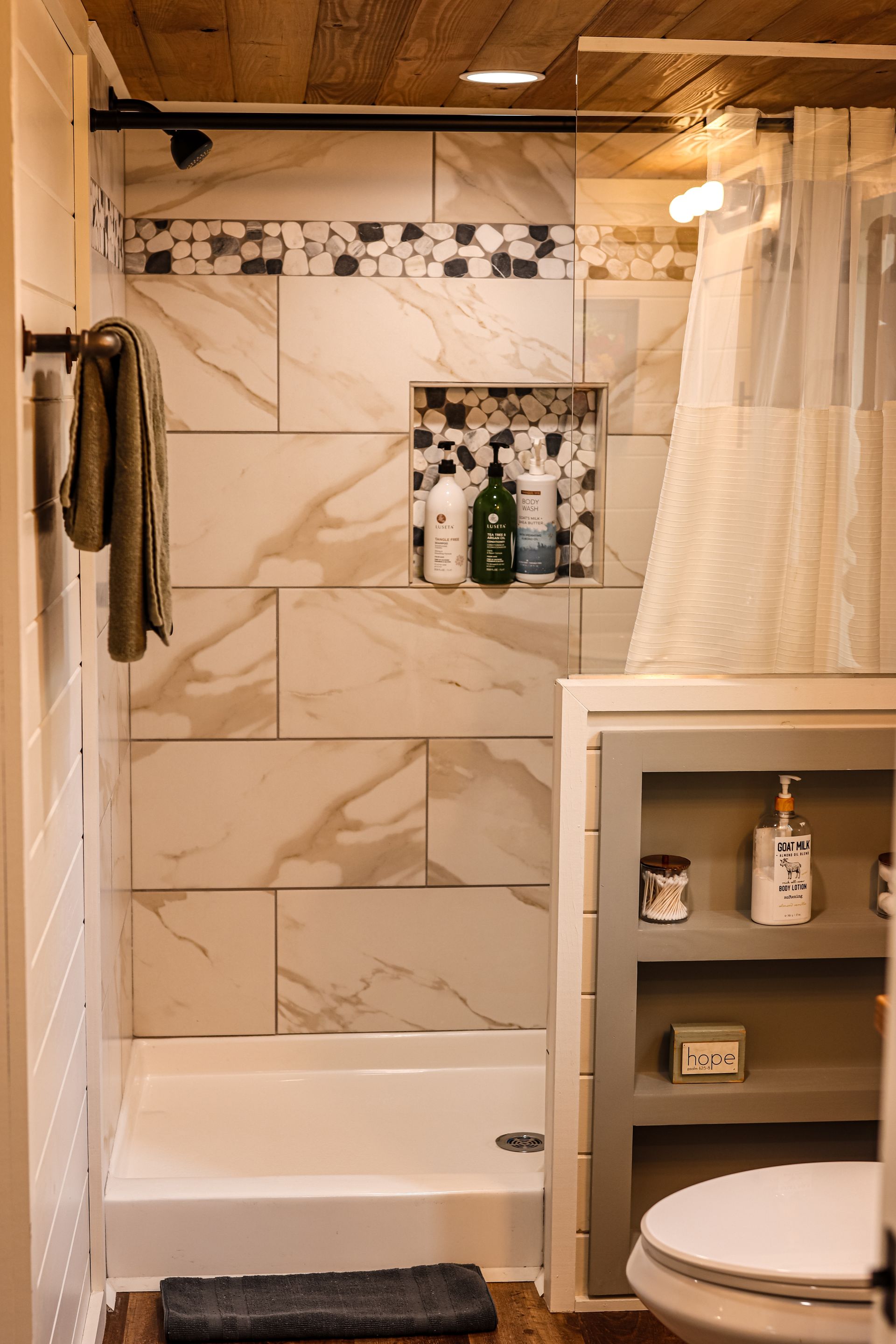 A bathroom with a shower , toilet , and bathtub.