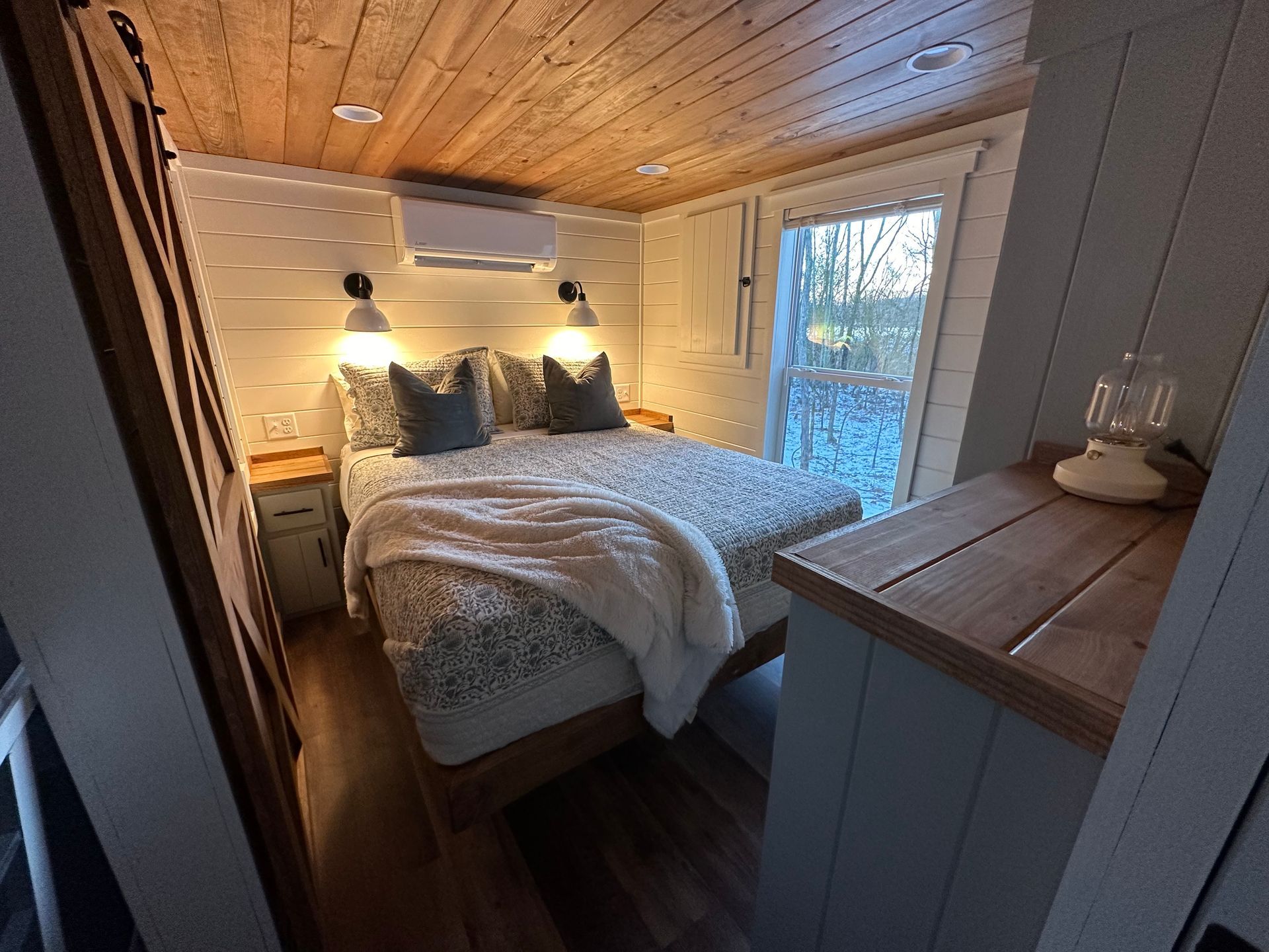 A bedroom with a bed , nightstands , and a window.