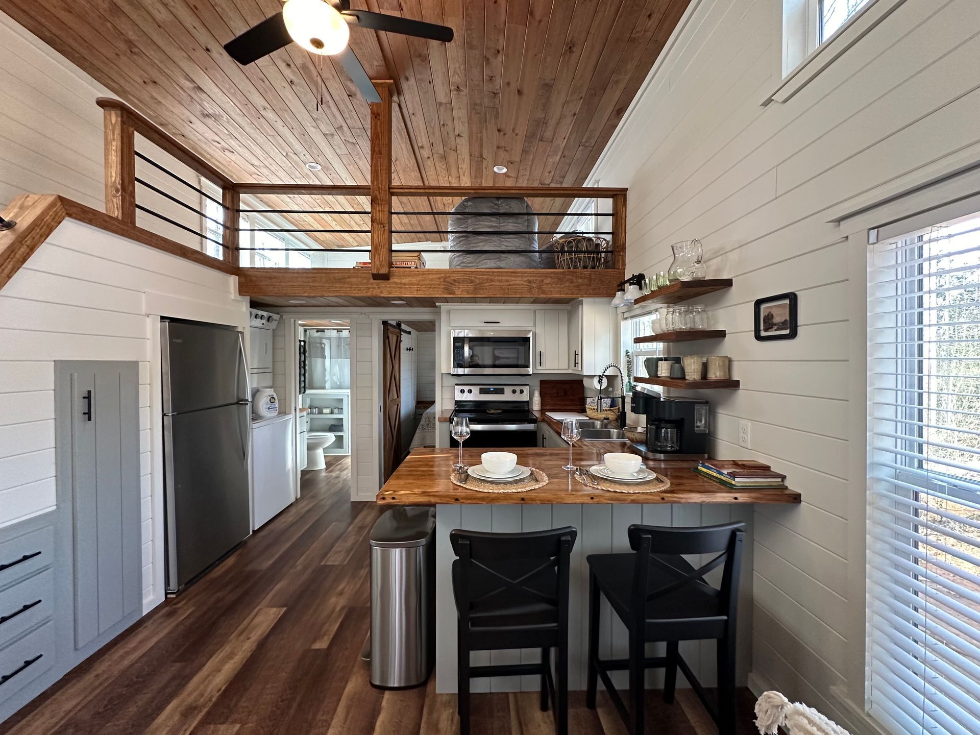 A kitchen in a small house with a ceiling fan.