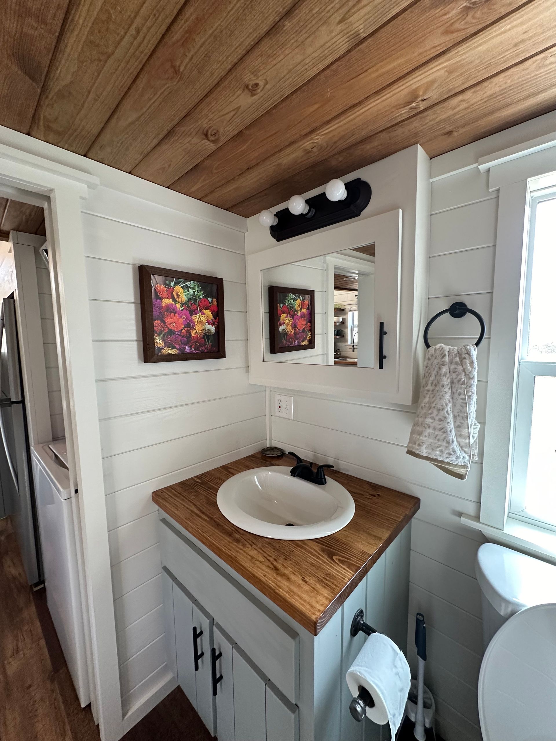 A bathroom with a sink , toilet and mirror.