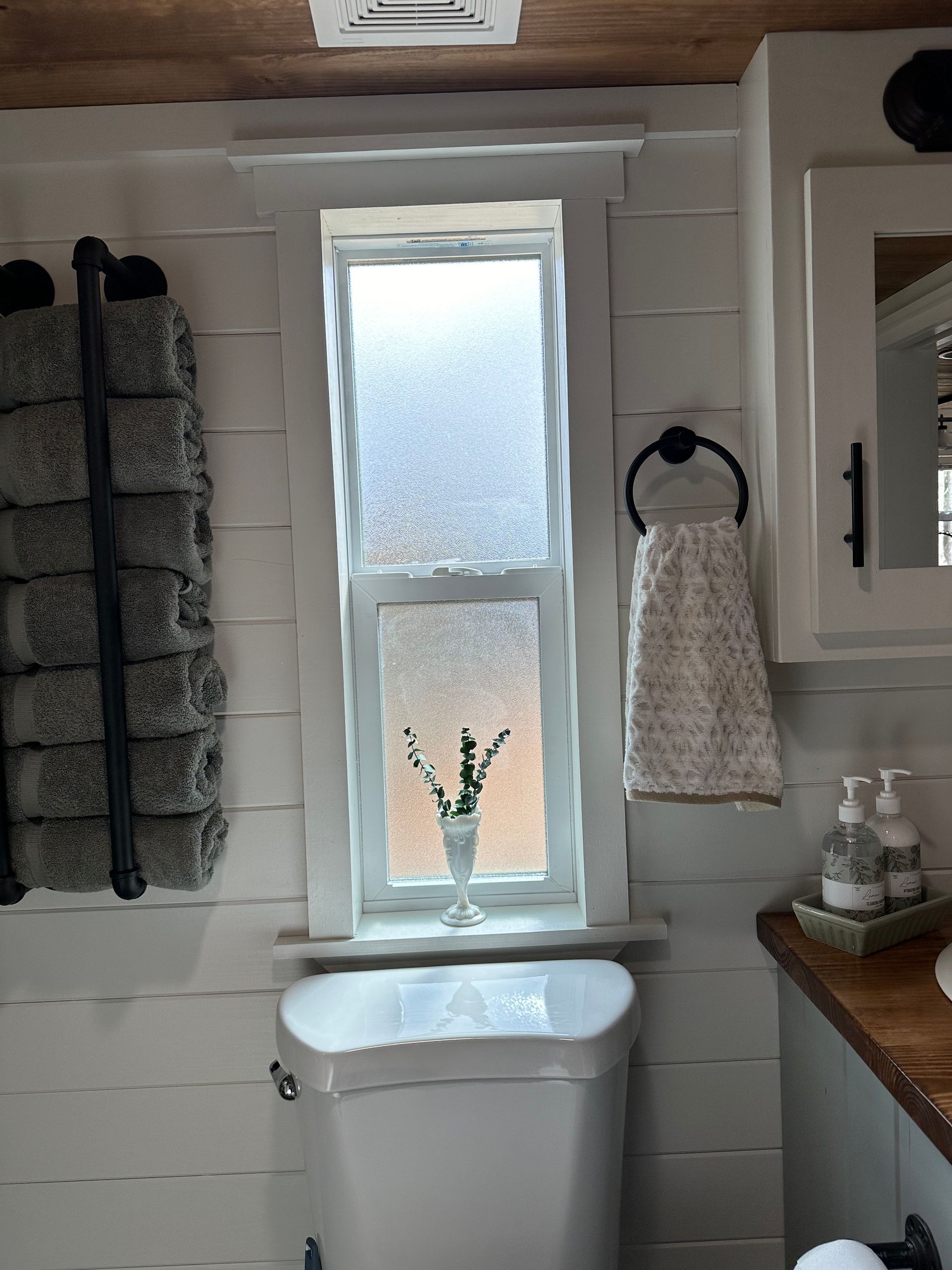 A bathroom with a toilet and a window.