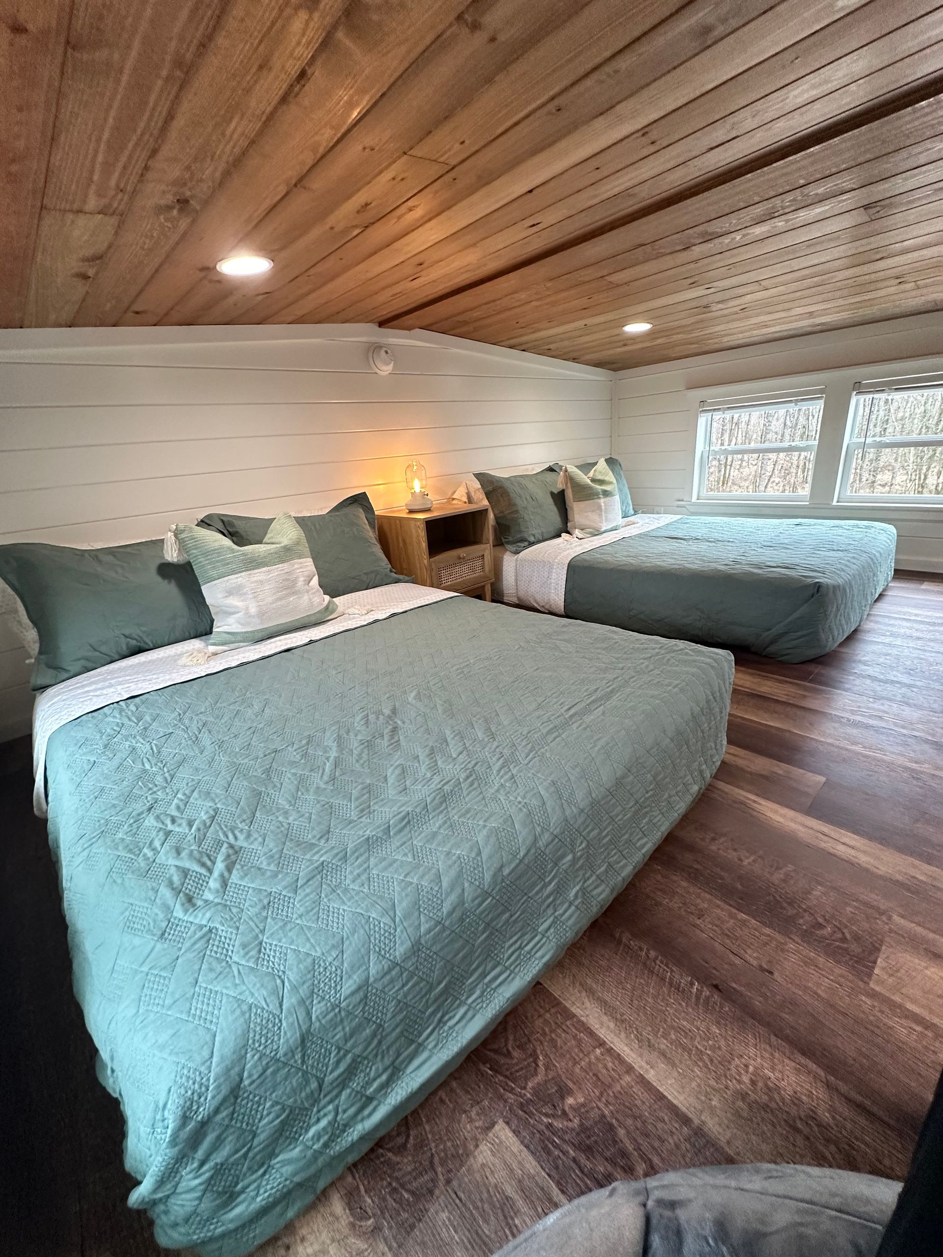 A bedroom with two beds and a chair.