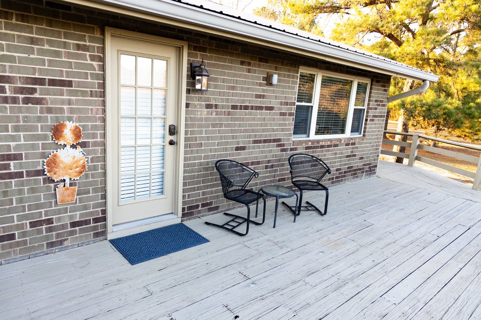 A brick house with a deck with chairs and a table