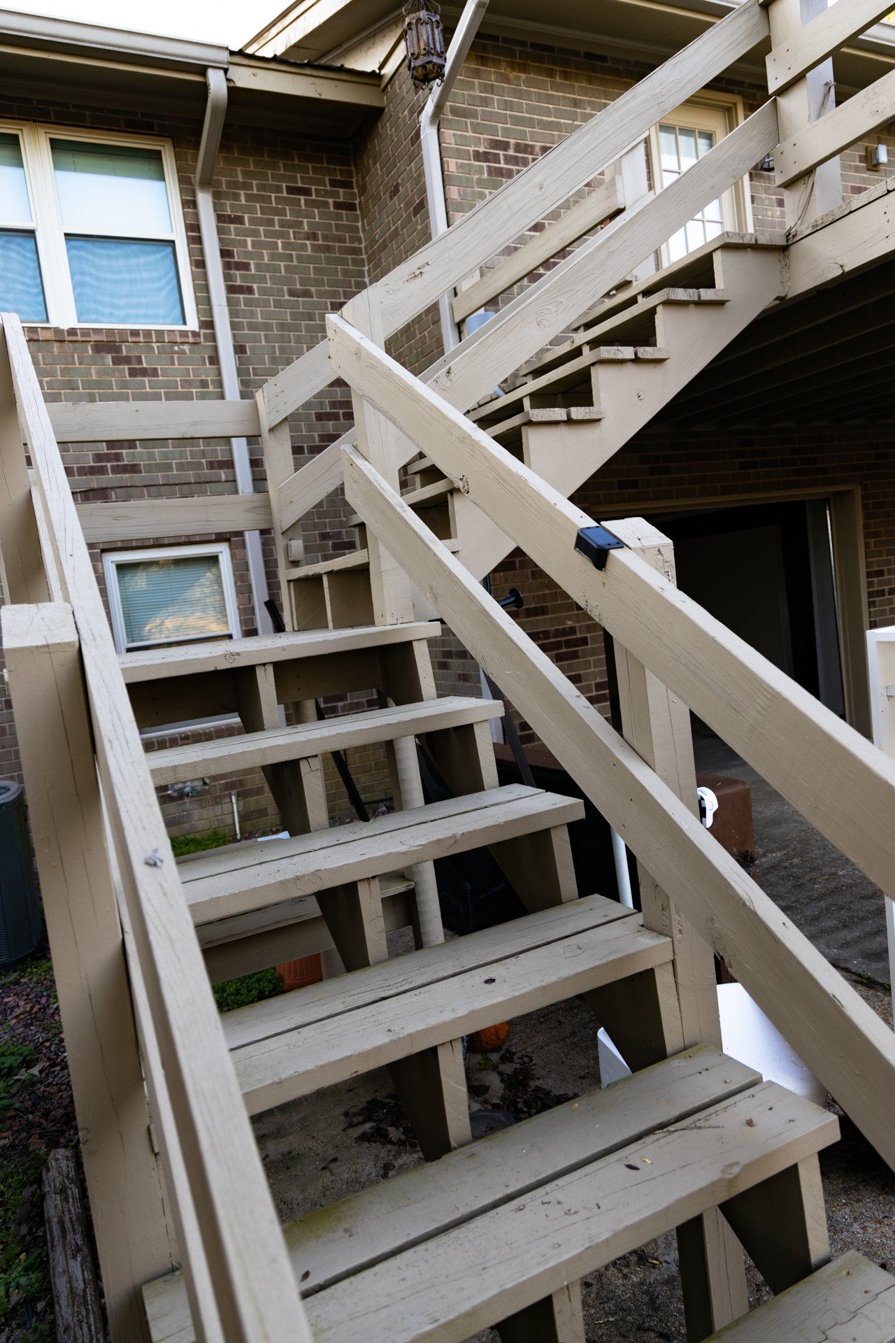 A set of wooden stairs leading up to a brick building