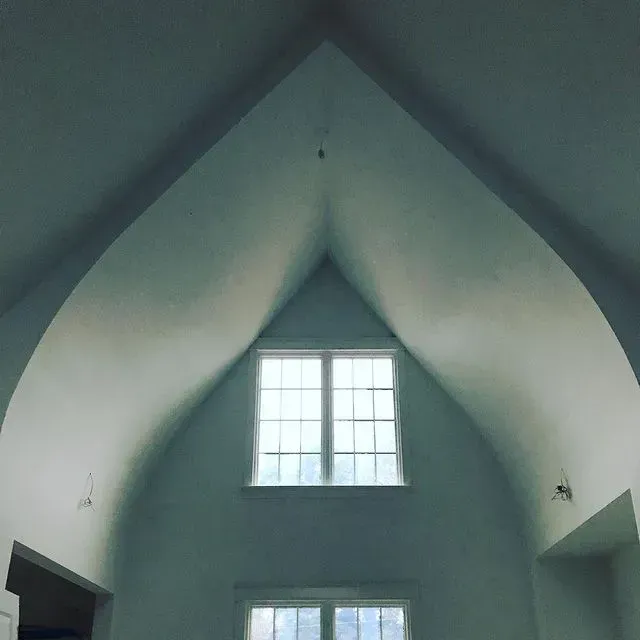 Interior with a vaulted ceiling and two small windows letting in daylight