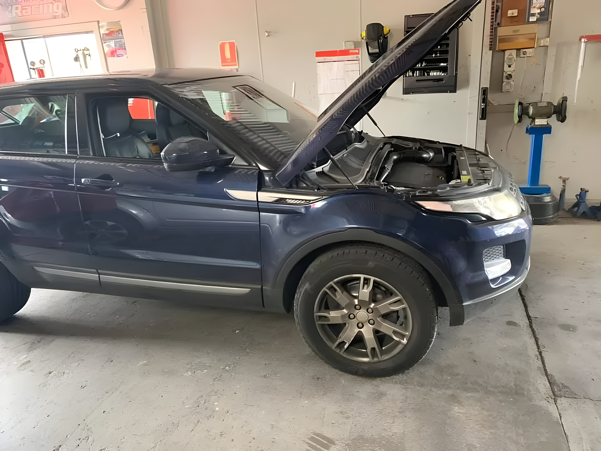 Dark Blue SUV with Hood Open in a Garage
