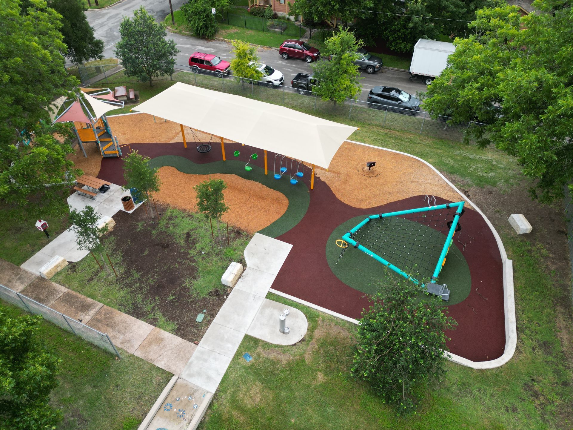 An aerial view of a park with a playground and a covered area.
